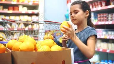 在杂货店买数字平板电脑的小女孩在网上买橘子水果。 在超市生活的小女孩